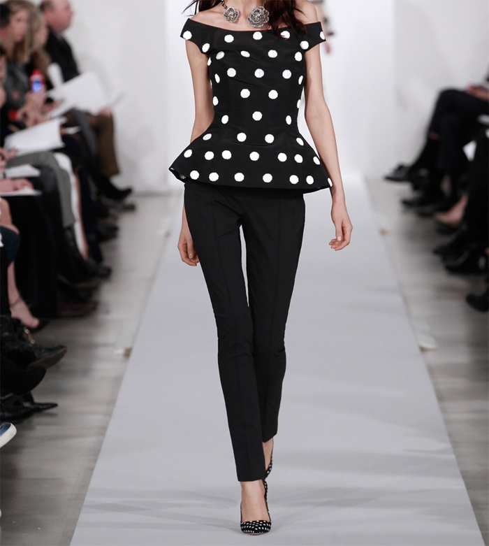 Model on runway wearing Oscar de la Renta off the shoulder polka dot bead embroidered peplum top