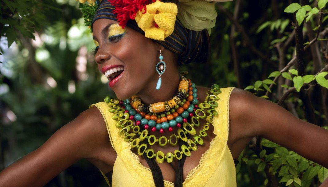 pretty woman in yellow with many colorful necklaces and flowers in hair