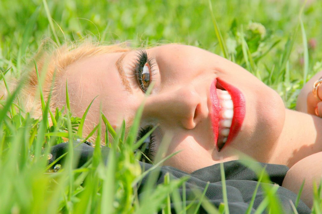 pretty girl smiling lying in grass