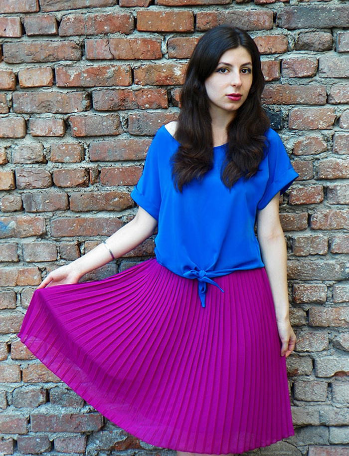 Blogger Laura Tenshi wears electric blue top with purple pleated skirt