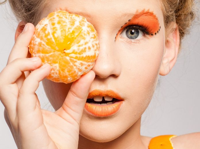 Pretty girl modeling with tangerine