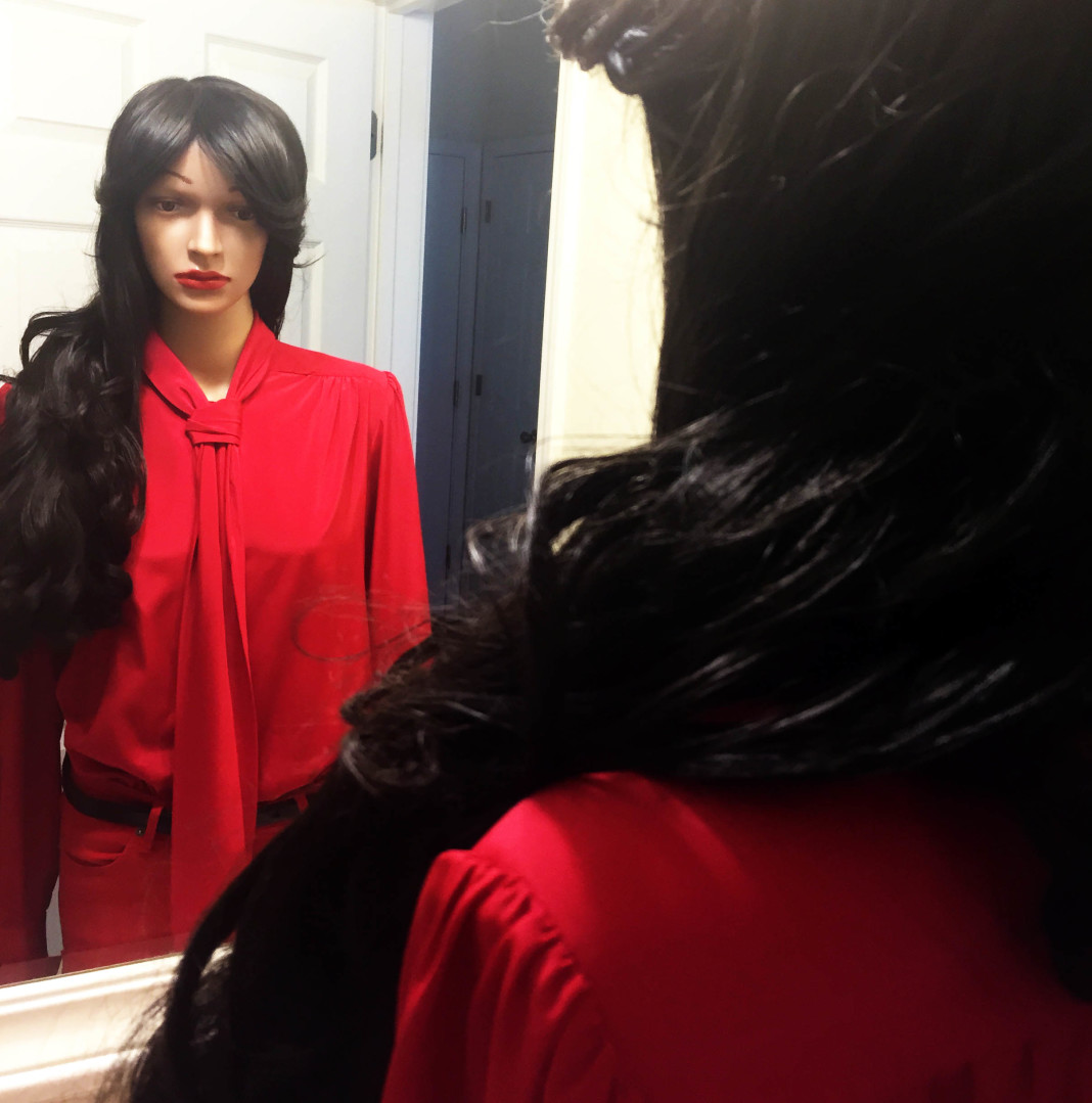 mannequin wearing red skinny jeans red blouse looking at reflection in mirror