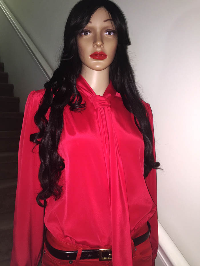 mannequin wearing red skinny jeans red blouse standing in front of stair case
