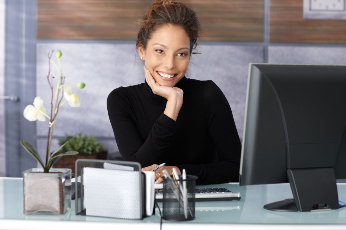woman wearing black sitting at desk in office black sweater outfit