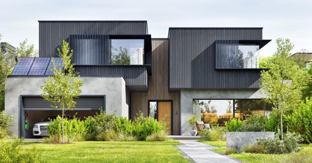 A modern, two-story home has large picturesque windows with timber cladding in light-wood and black stain colors.